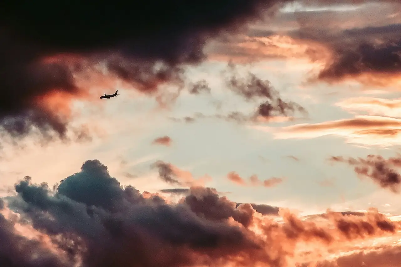 An aircraft silhouetted against a sunset sky
